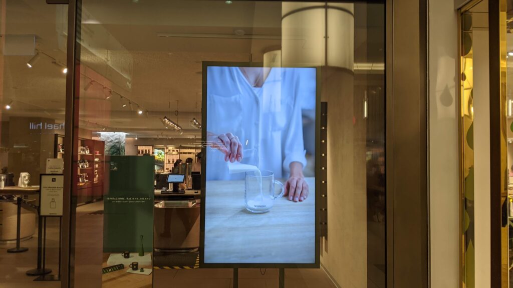 A display is showing a video that a woman is pouring milk.